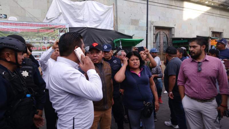 Se resisten ambulantes a retirarse del zócalo de la capital; corren con palos a policías municipales